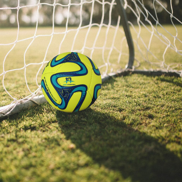 A miniature football on a green field, ready for a game